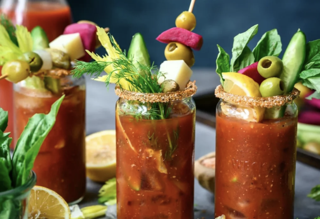 Bloody Mary cocktail garnished with shrimp, pickles, olives, and celery.